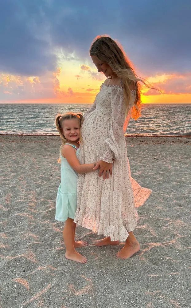 Mother and daughter at sunset on the beach