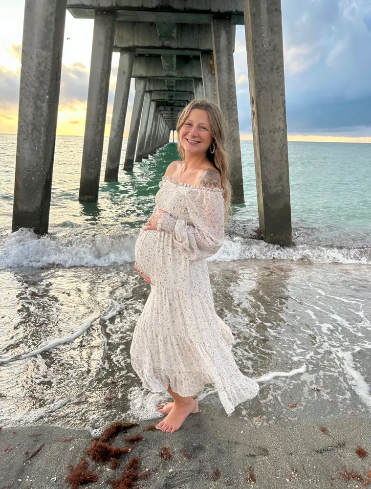 Expecting mother laughing on the beach
